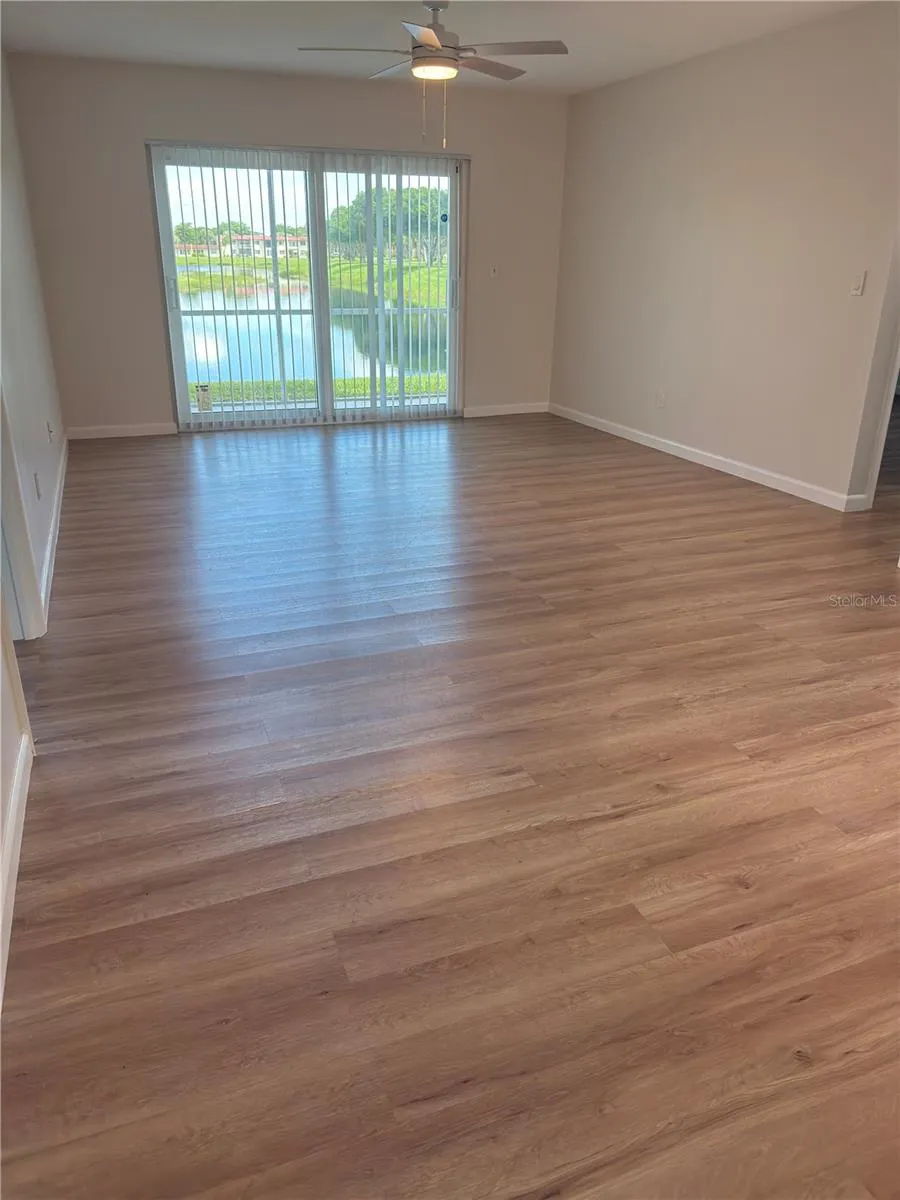 Open floor plan living room with screened porch and water view
