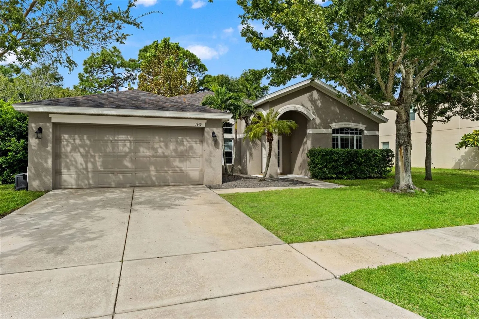 An extended driveway and two-car garage provide plenty of everyday parking and storage convenience.