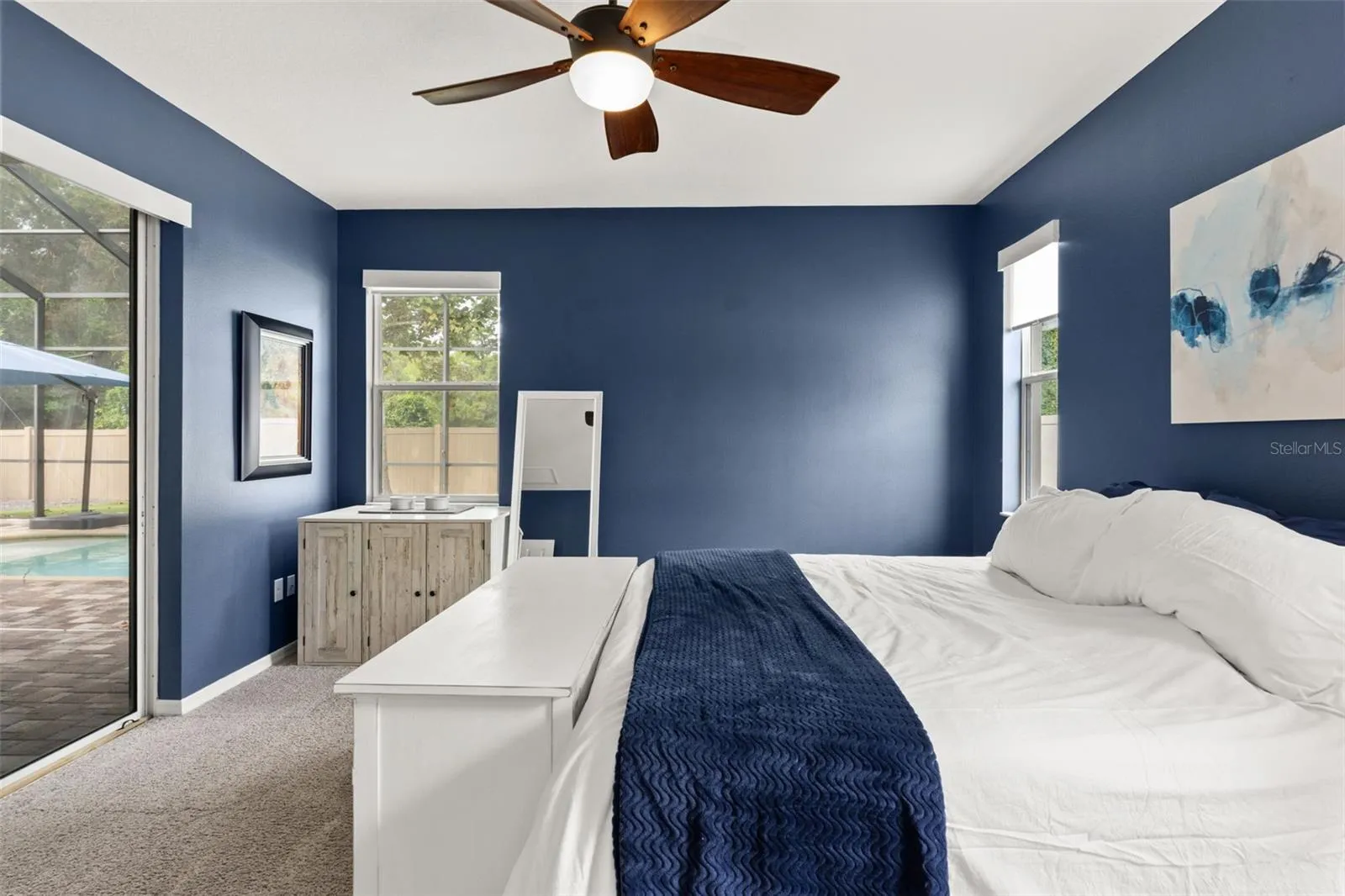 Multiple windows and direct access to the screened lanai bring natural light and the Florida outdoors right into the primary suite.