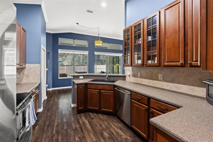 A large window over the sink brings natural light into the kitchen and provides a view toward the outdoor living area.