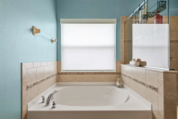 Unwind in the primary bath’s soaking tub, positioned beneath a large window for a bright, relaxing feel.
