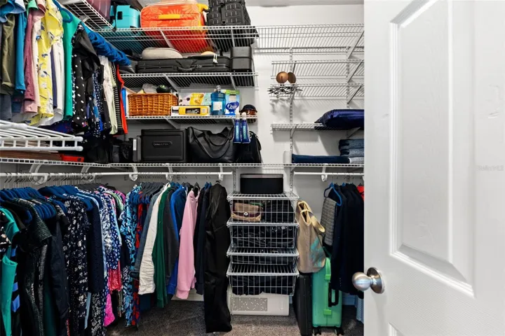 A large walk-in closet with built-in organization provides plenty of room to keep clothing, shoes, and accessories neatly arranged.