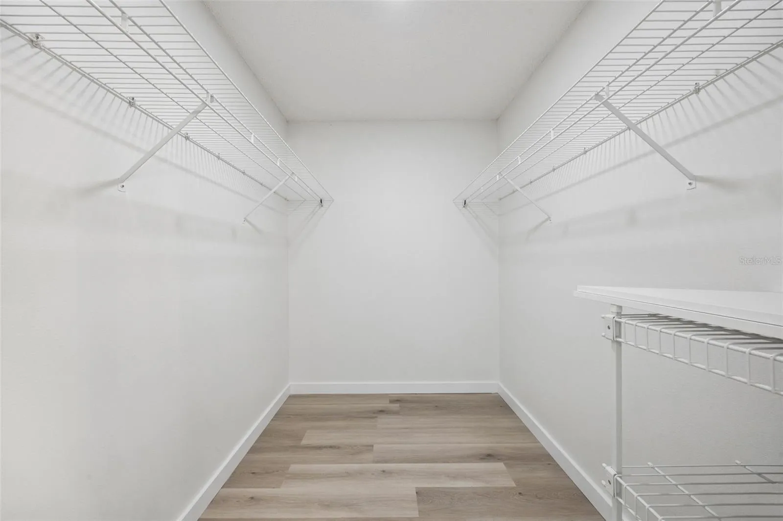 one of two walk-in closets with the Primary Bedroom