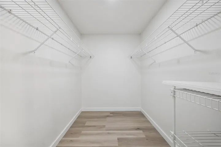one of two walk-in closets with the Primary Bedroom