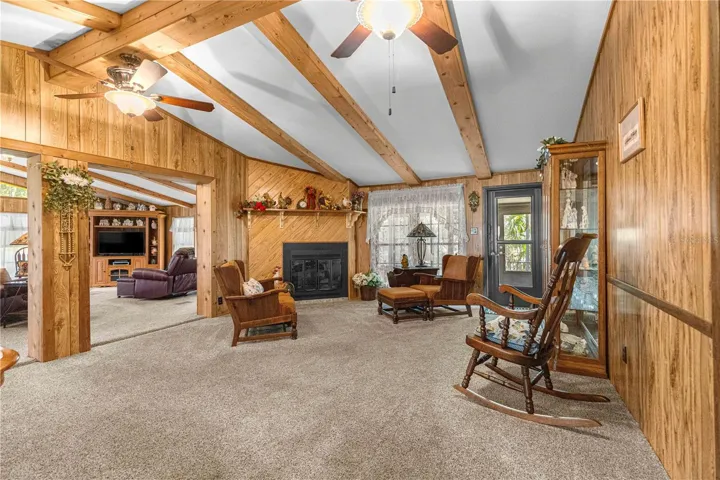 Fireplace sitting area with exposed wood beams.