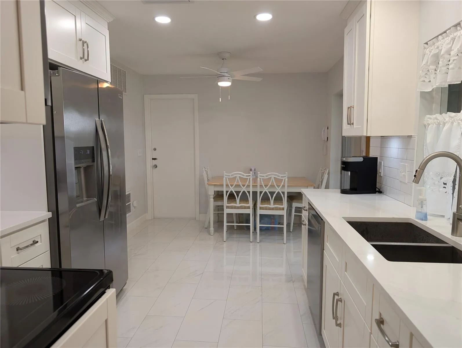 View from dining room thru kitchen to eat in area.  Kitchen door leading to garage and laundry area.