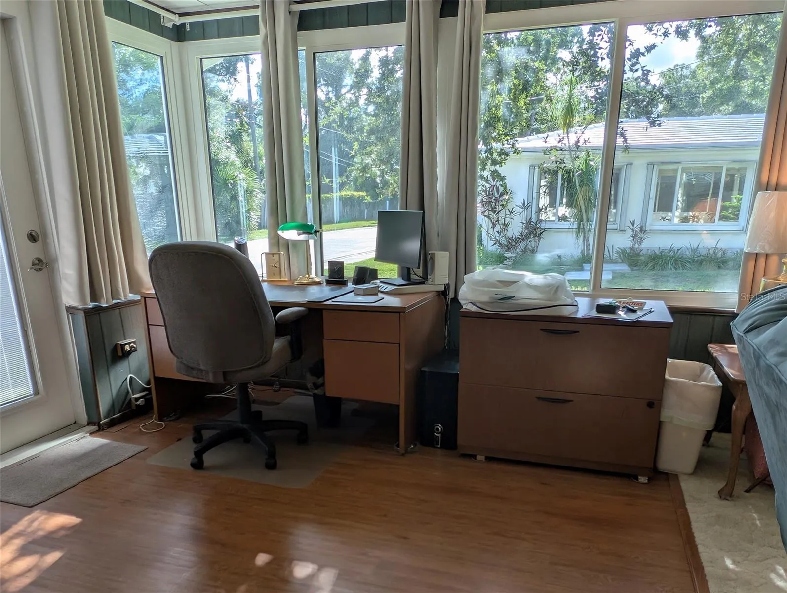 Florida room dedicated space for office has Home Decorator Woodstock Luxury Vinyl Plank flooring.  Wall AC unit (not shown). Exterior access door to side yard.