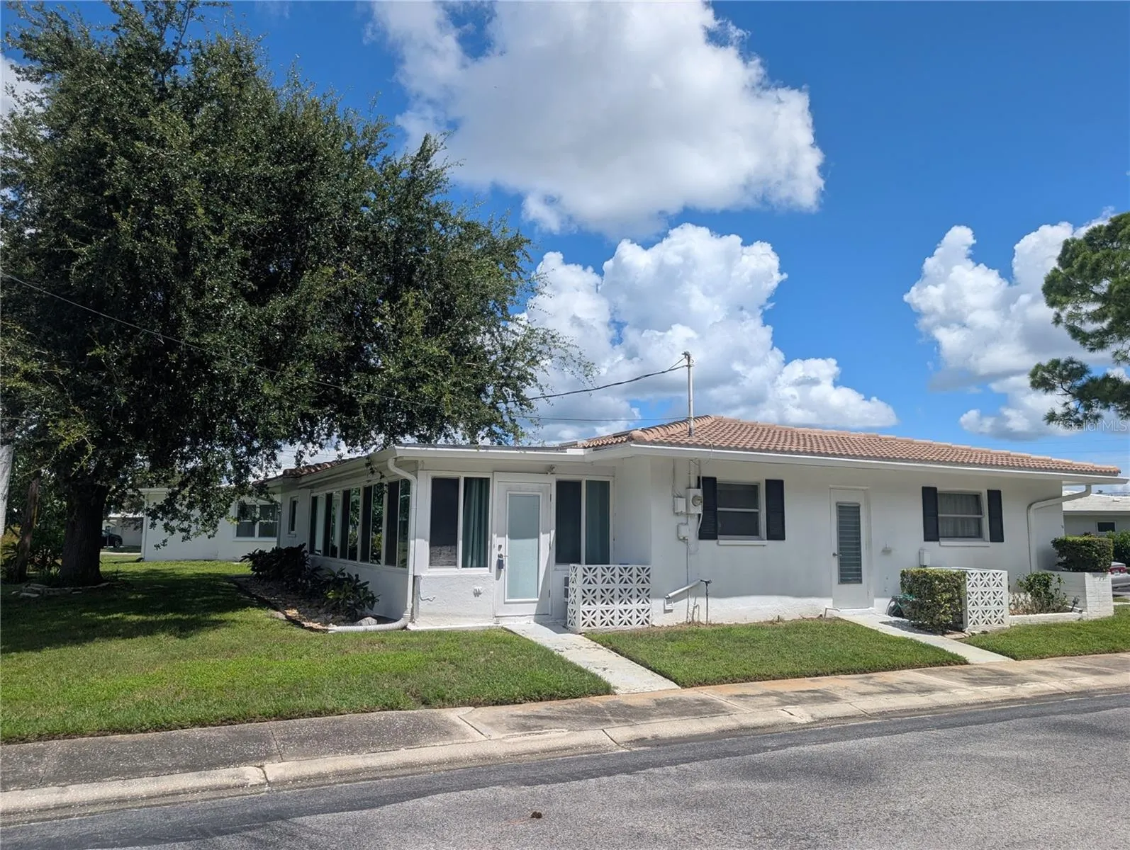 Side door from Florida room accesses side and backyard. Garage man door also shown. Flat roof installed 2020.