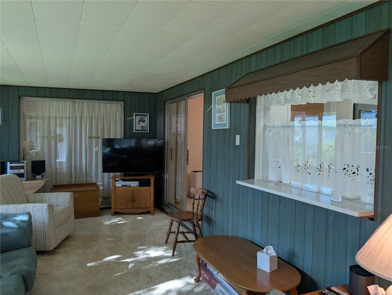 View of window to kitchen, access to dining room and slider to Primary bedroom.
