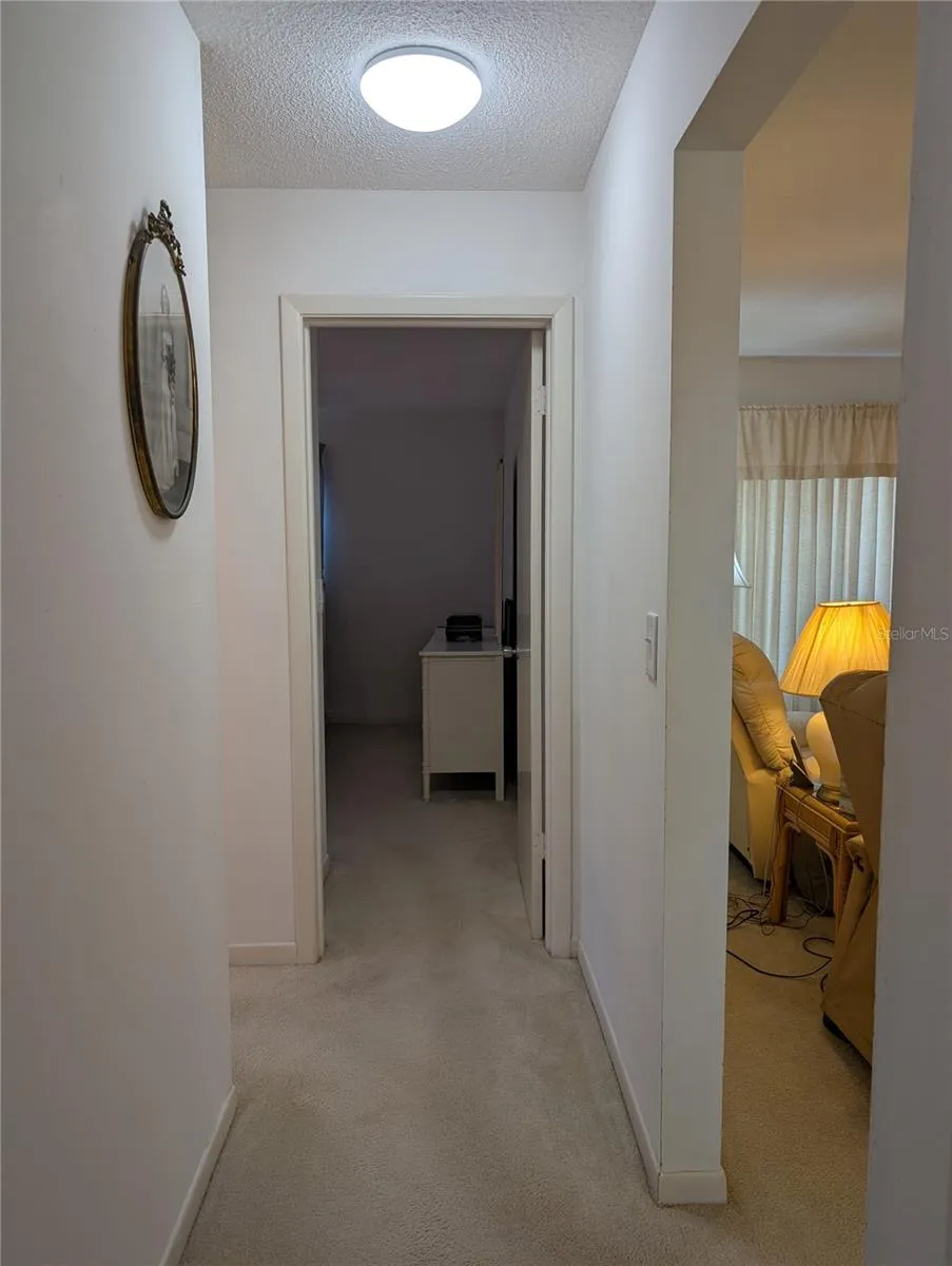 View from primary to guest bedroom. Main bathroom to left before bedroom. Living area to right.