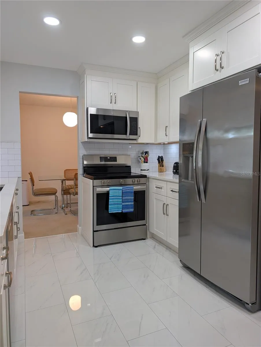 View thru kitchen to dining room. 2024 Frigidaire Gallery Appliance package includes refrigerator, range, microwave and dishwasher.