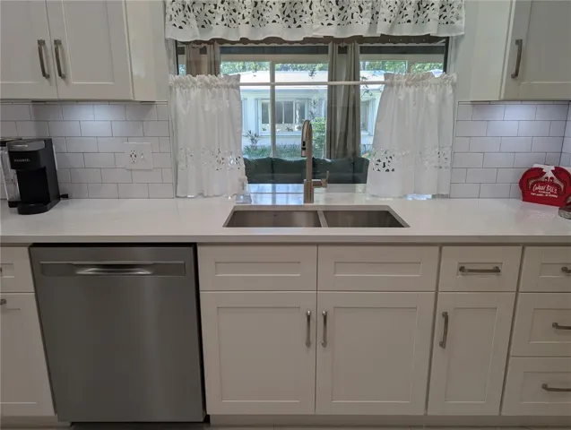 Stainless undermount sink, tall kitchen faucet w/pull down sprayer and stainless steel hardware.