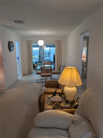 View from living room to dining room into Florida room.  Kitchen to left, bedroom/bathrooms to right.