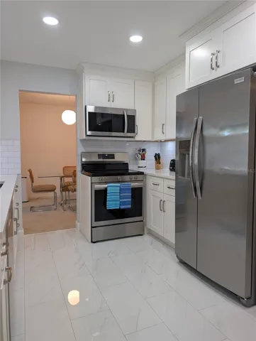 View thru kitchen to dining room. 2024 Frigidaire Gallery Appliance package includes refrigerator, range, microwave and dishwasher.