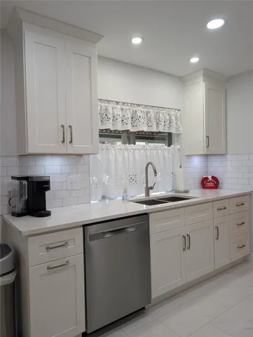Kitchen window looks into Florida room. Updated kitchen also features gorgeous tile flooring, 36" white shaker wood cabinets w/soft close door/drawer and inset lights (no drop popcorn ceiling).