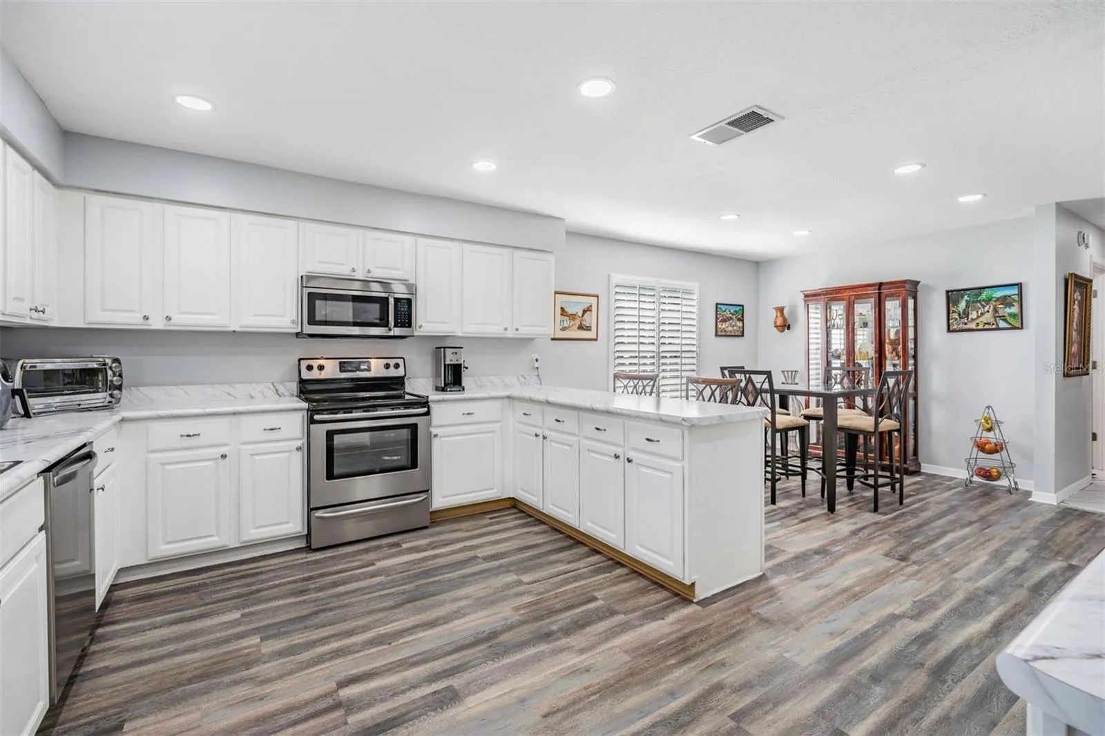 Spacious kitchen with custom quartz counters and tile backsplash