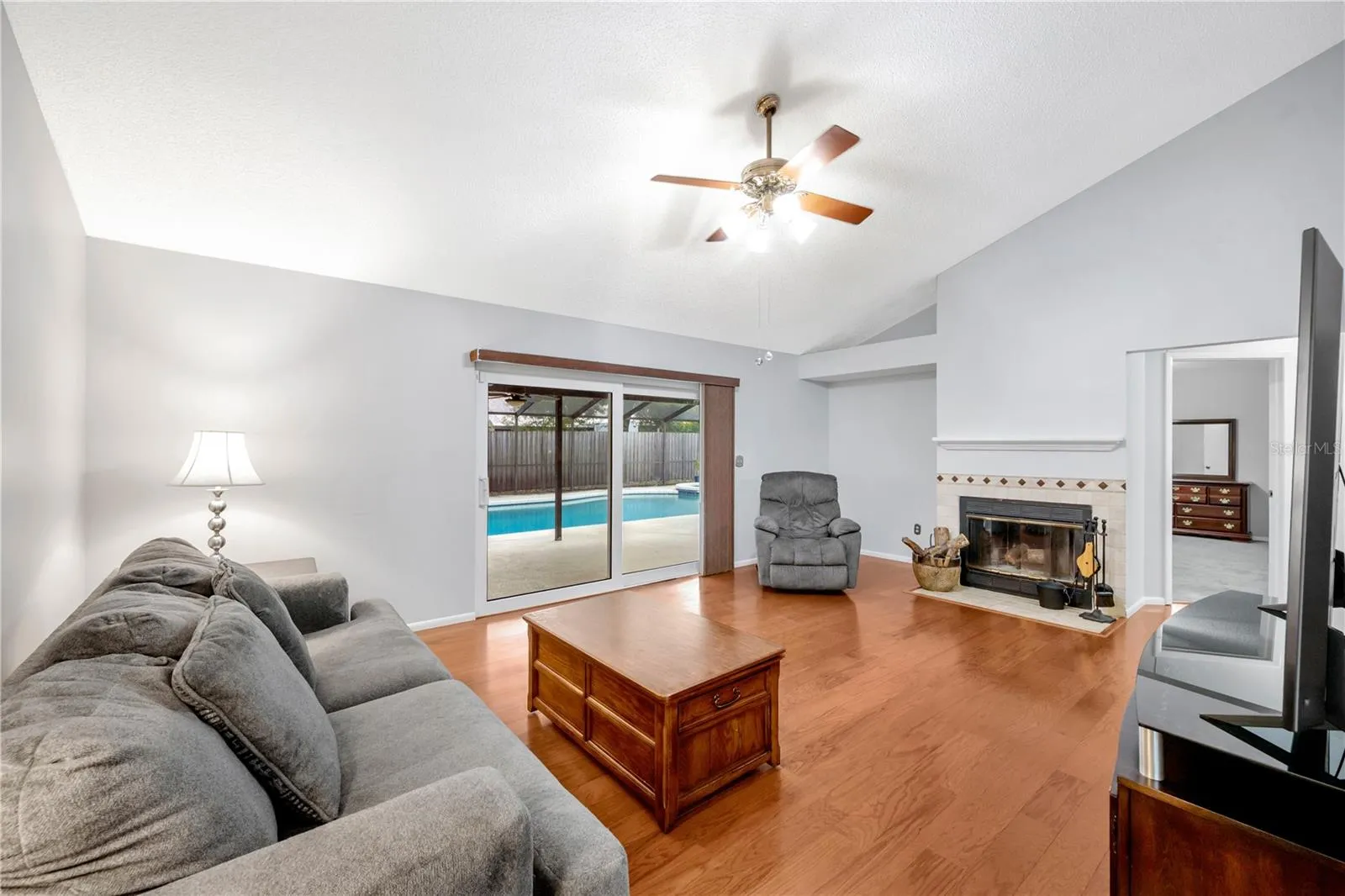 The inviting family room is filled with character, showcasing vaulted ceilings and a real wood-burning fireplace.