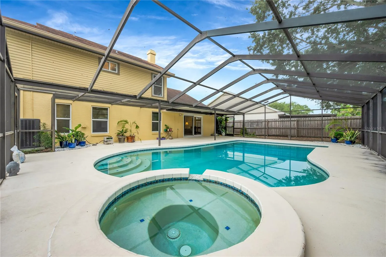 The backyard is sure to be a favorite gathering spot, featuring a deep, propane-heated pool and spa, all surrounded by a huge screened lanai.