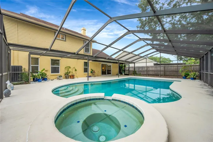 The backyard is sure to be a favorite gathering spot, featuring a deep, propane-heated pool and spa, all surrounded by a huge screened lanai.
