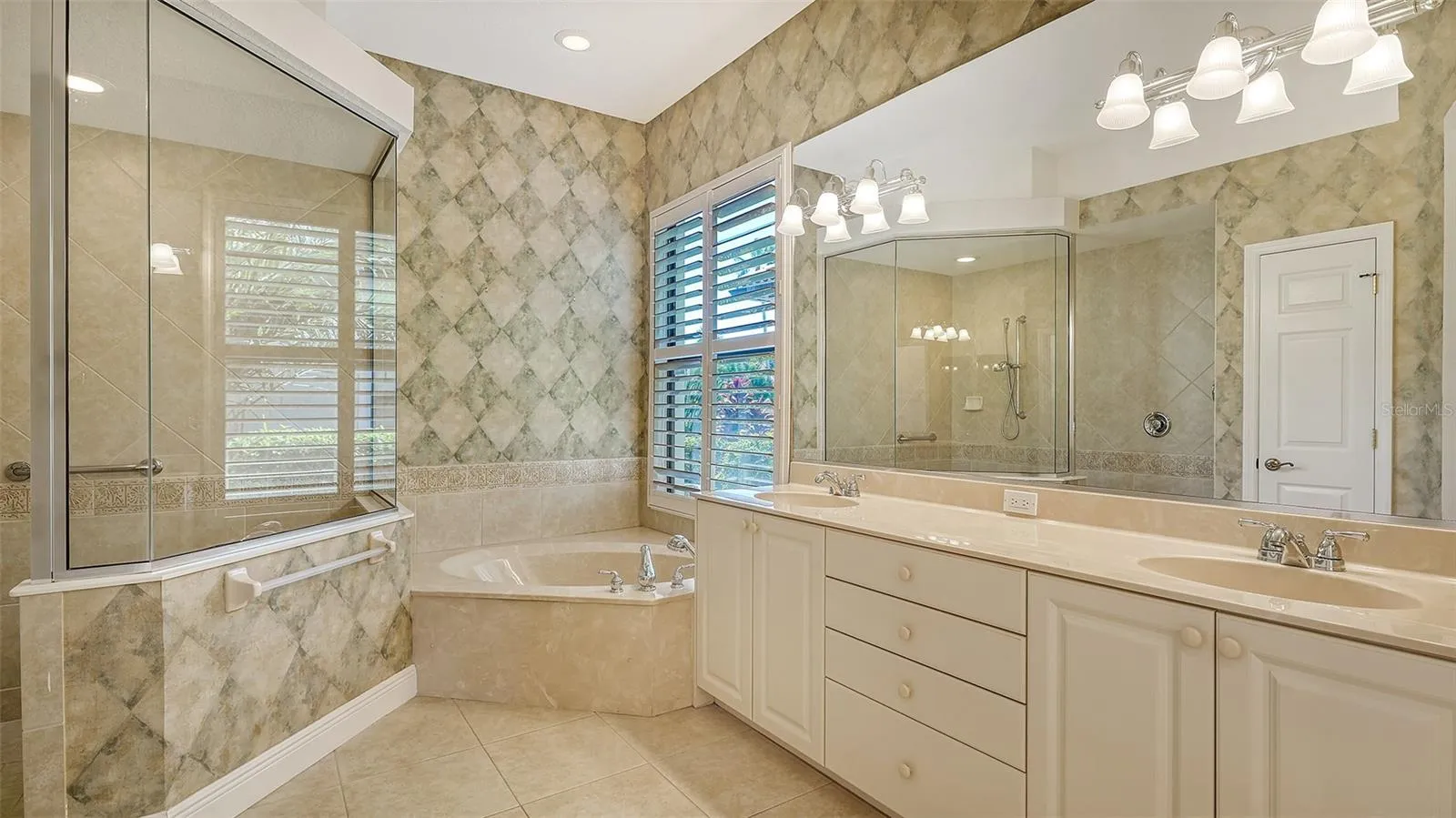 master bathroom with double vanities, soaking tub and walk in shower