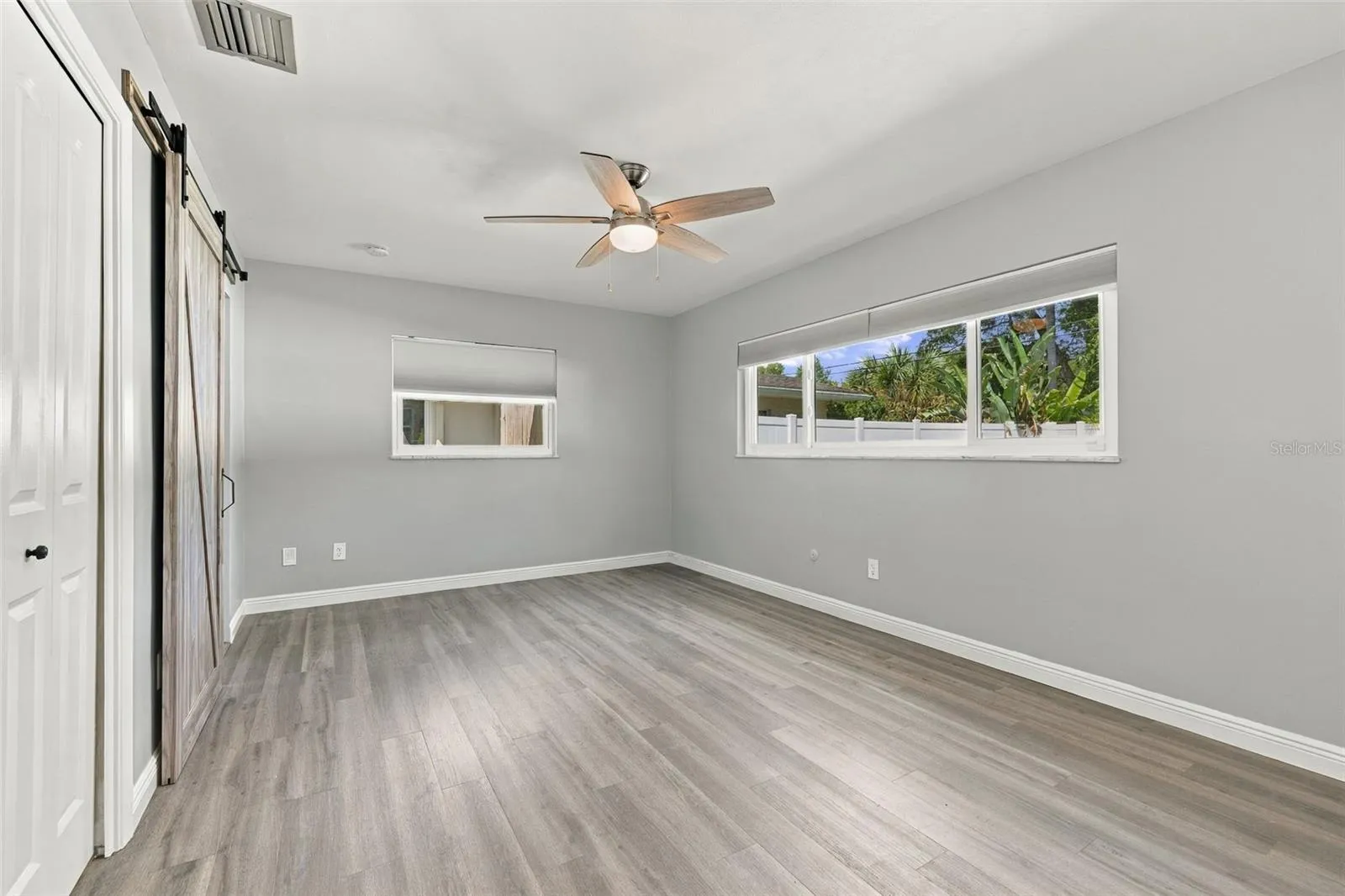 The primary bedroom has a walk-in closet and barn door to the ensuite bathroom.