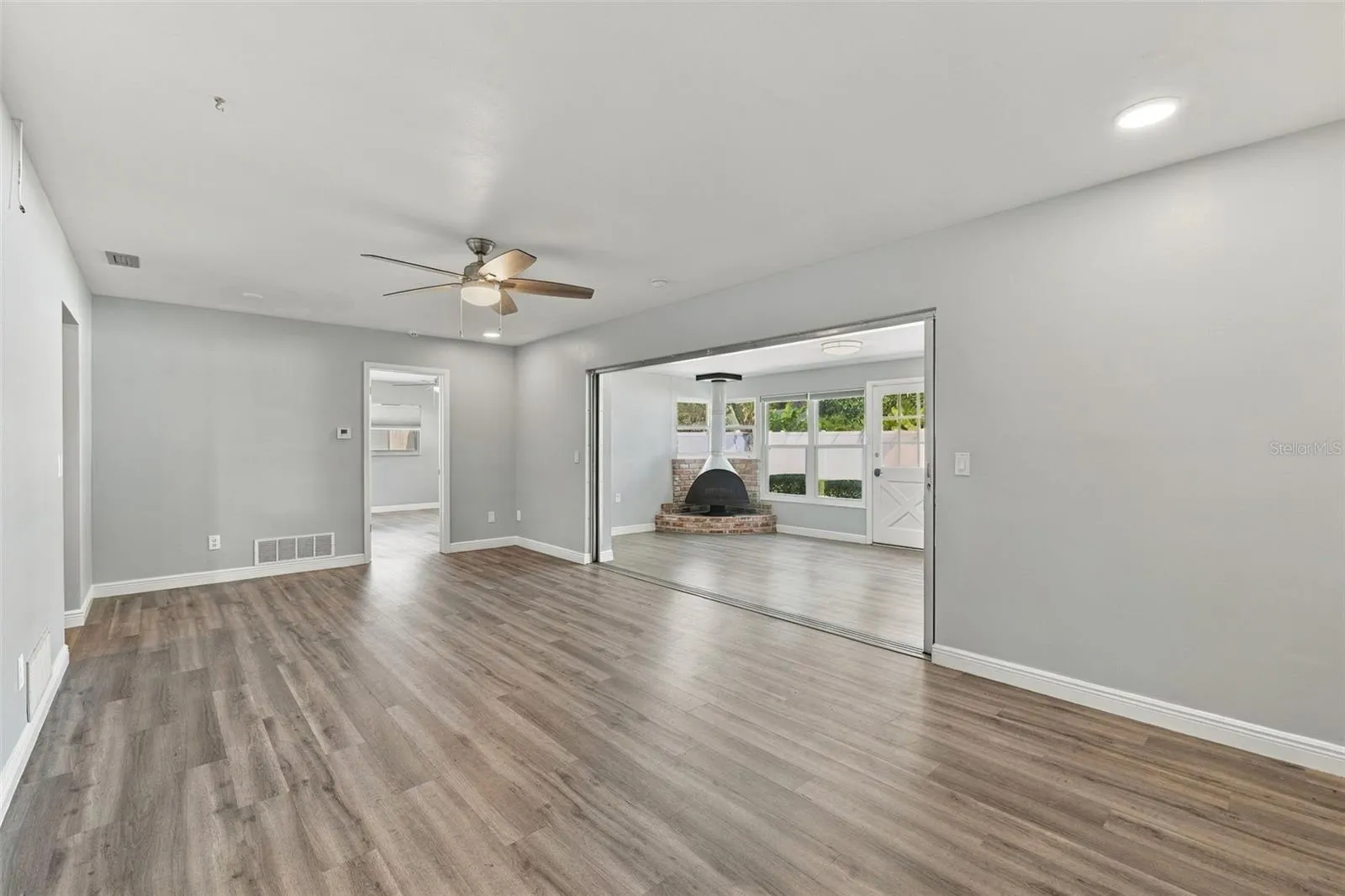 This large room off the kitchen also opens up to the Florida room and fireplace. The door on the far wall is to the primary bedroom and ensuite bathroom.