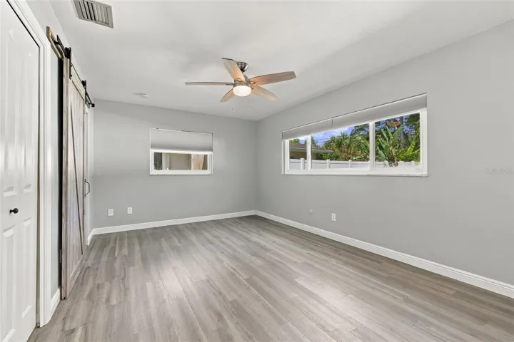 The primary bedroom has a walk-in closet and barn door to the ensuite bathroom.
