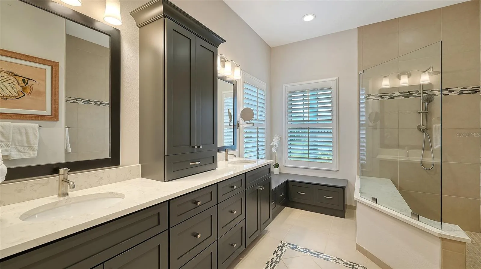 Master bath with custom cabinetry, quartz countertops, spacious walk in shower