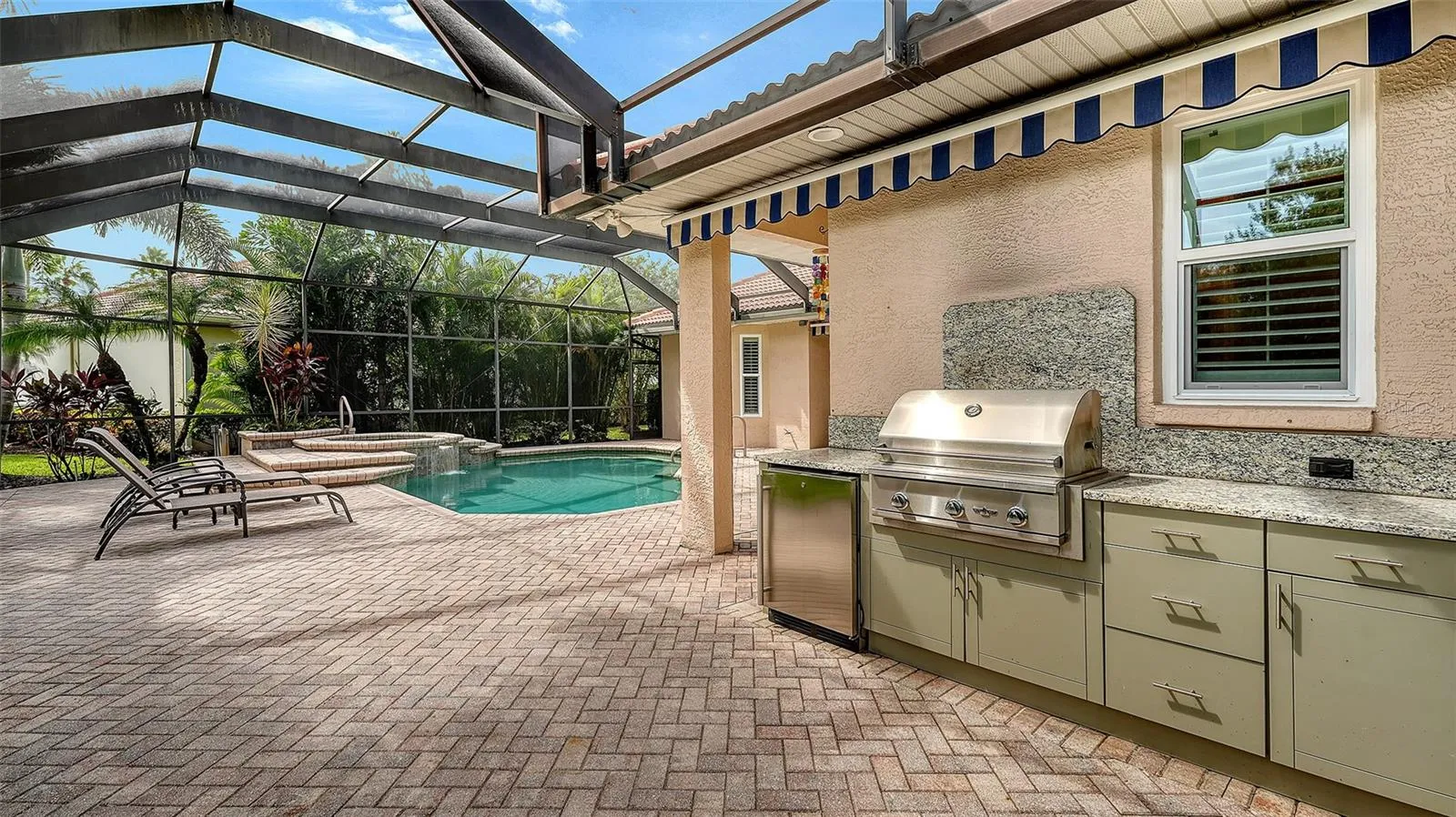 Outdoor kitchen with newer grill and retractable awning