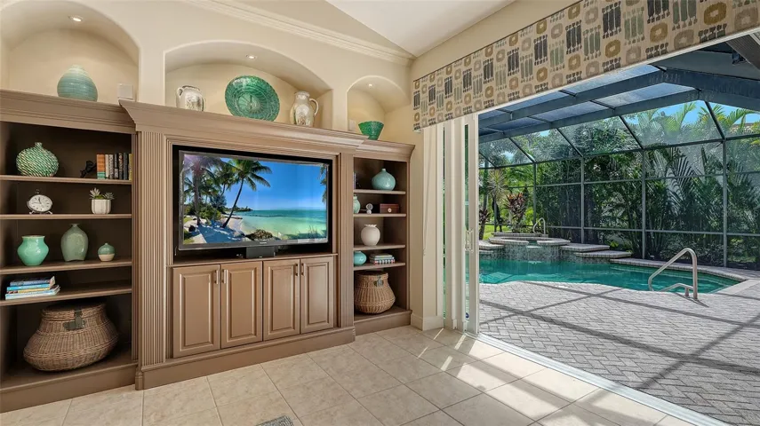 Great Room with large hurricane impact sliding glass doors and custom built in