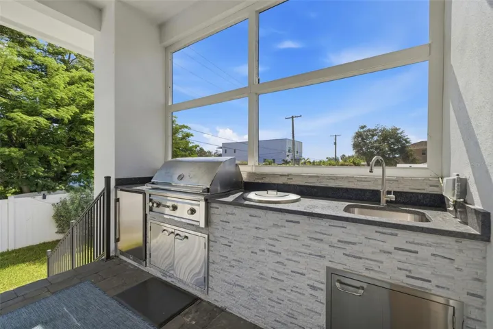 Enjoy the built-in outdoor kitchen with gas grill, fridge and sink.