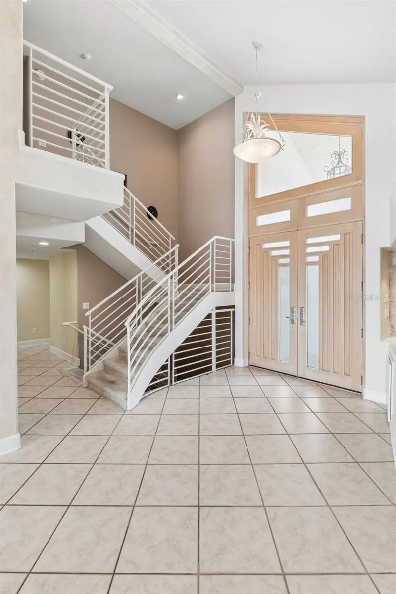 Staircase leading to the private upstairs primary suite, office/loft with lake-views.