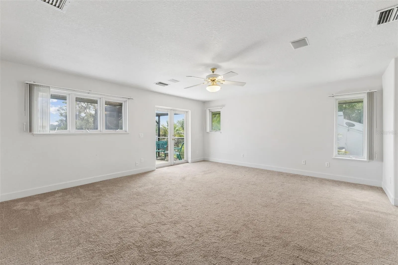 Spacious primary bedroom with beautiful lake views and French doors opening to a private balcony.