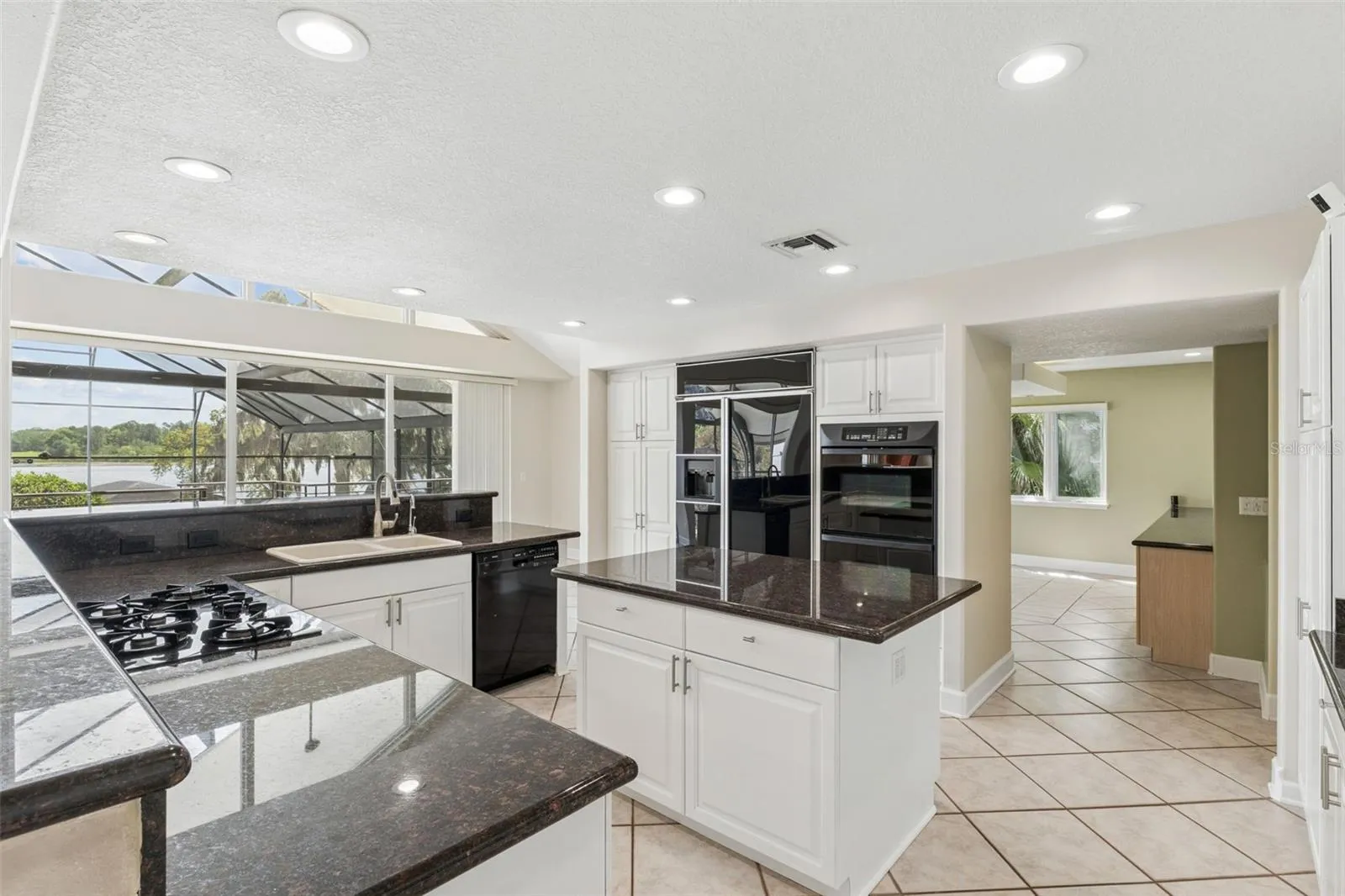 Spacious kitchen with lake views, center island, and seamless flow into the dining room.