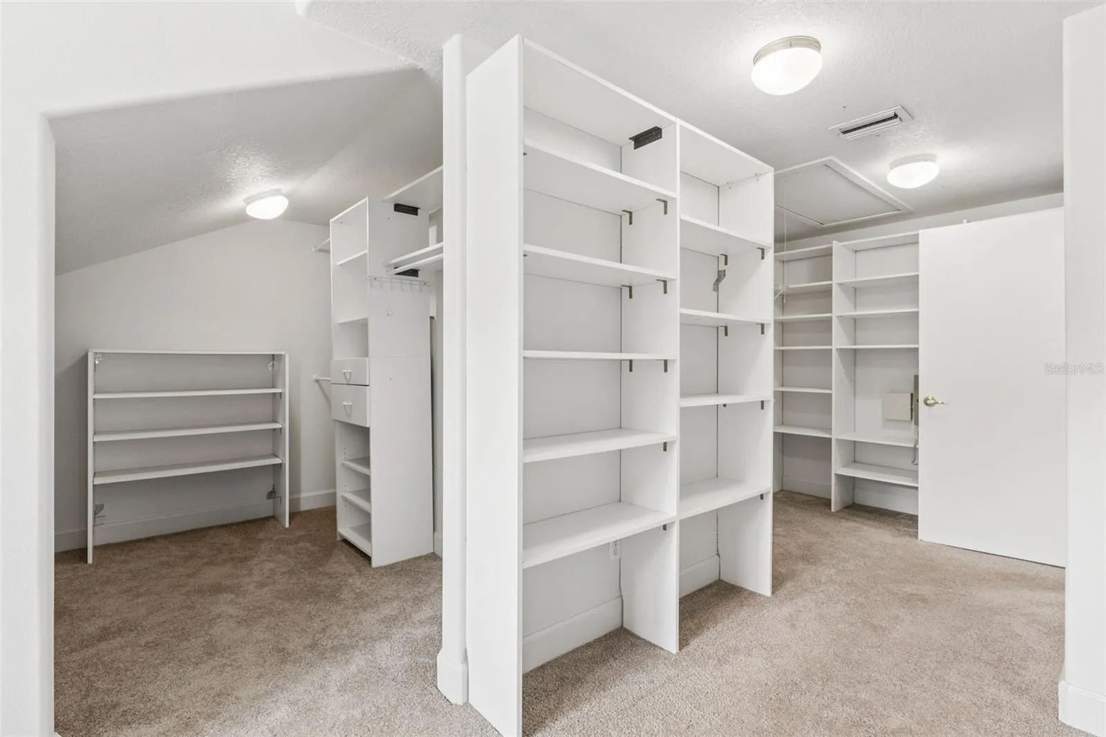 Massive walk-in closet with custom built-in shelving off the primary suite.