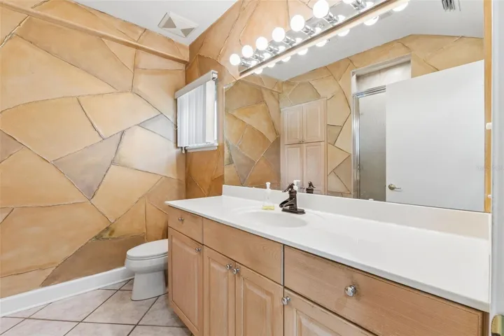 Full-size bathroom located near the laundry room and garage entry.