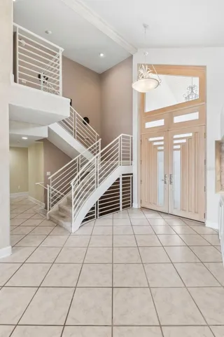 Staircase leading to the private upstairs primary suite, office/loft with lake-views.