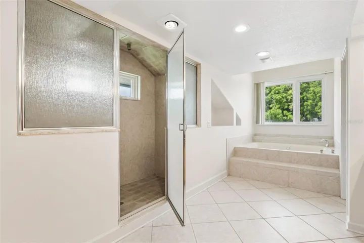 Primary bathroom with separate tub and walk-in shower.