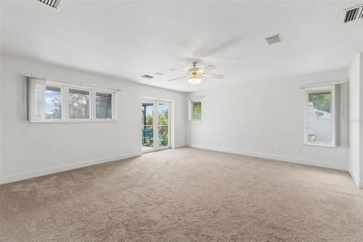 Spacious primary bedroom with beautiful lake views and French doors opening to a private balcony.