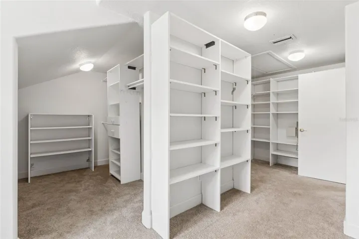 Massive walk-in closet with custom built-in shelving off the primary suite.