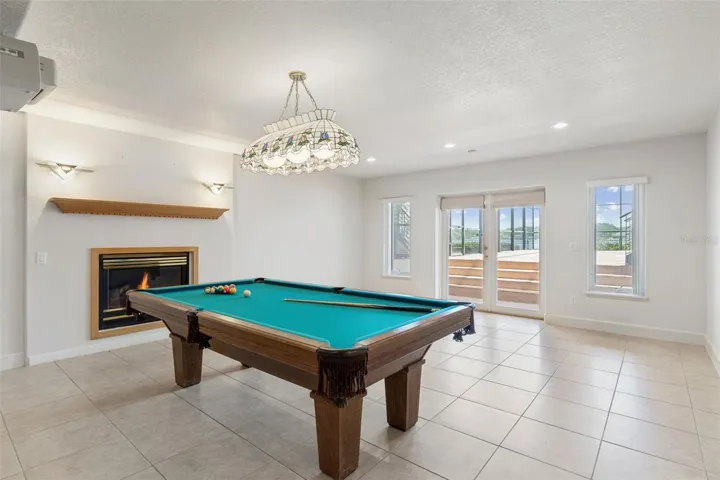 Full basement living room with fireplace and French doors opening directly to the pool deck.