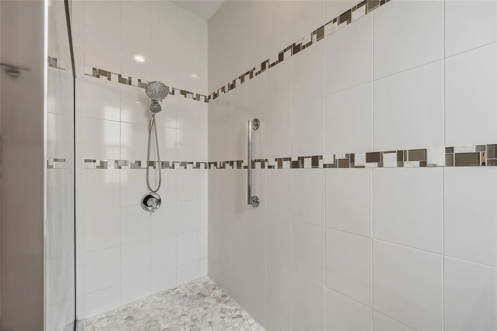 Oversized walk-in shower with decorative tile accents