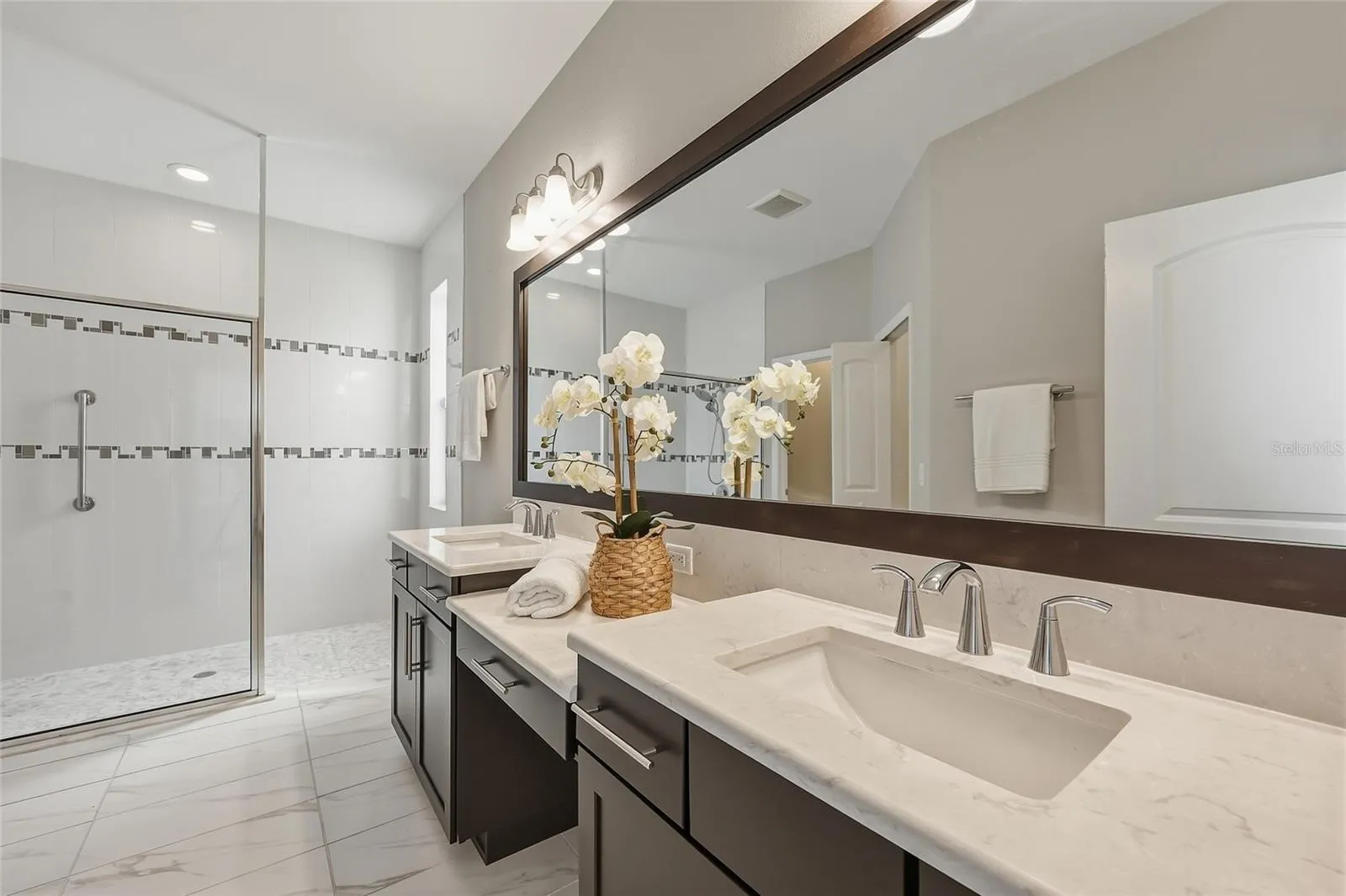 Private first floor en-suite bath with dual vanities and spacious walk-in shower