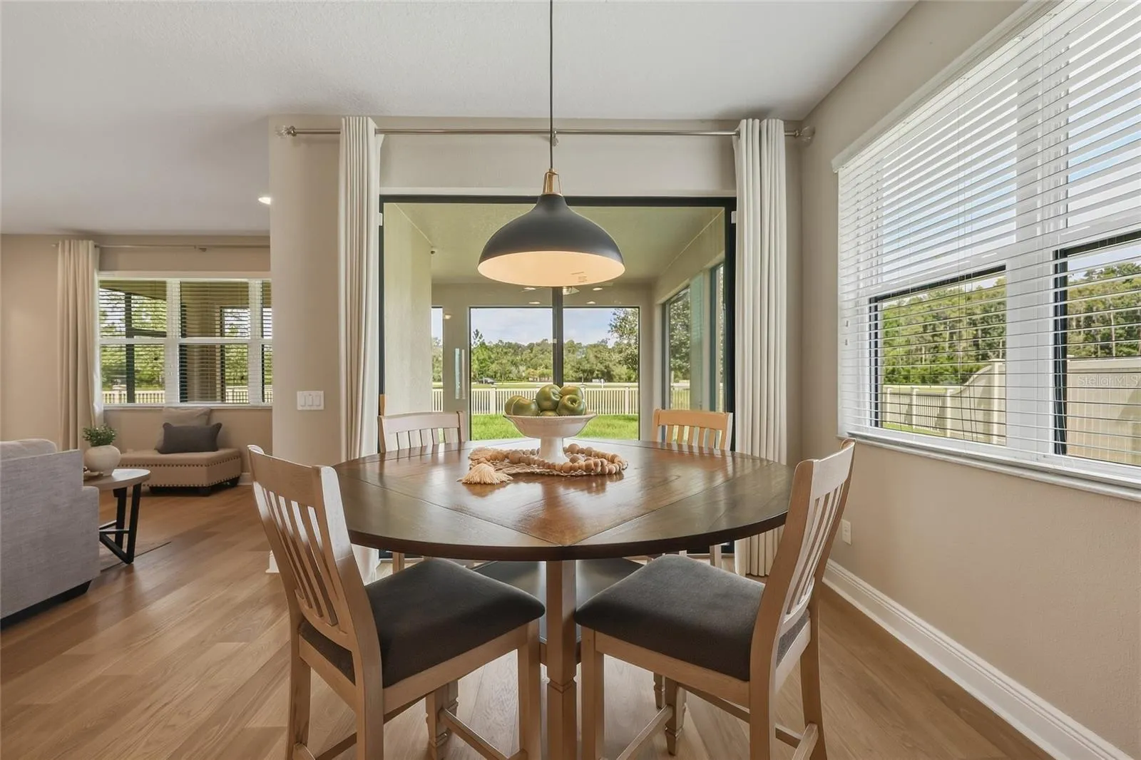 Light-filled eat-in kitchen with oversized window and sliding glass doors leading to the back patio