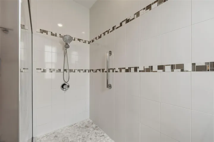 Oversized walk-in shower with decorative tile accents