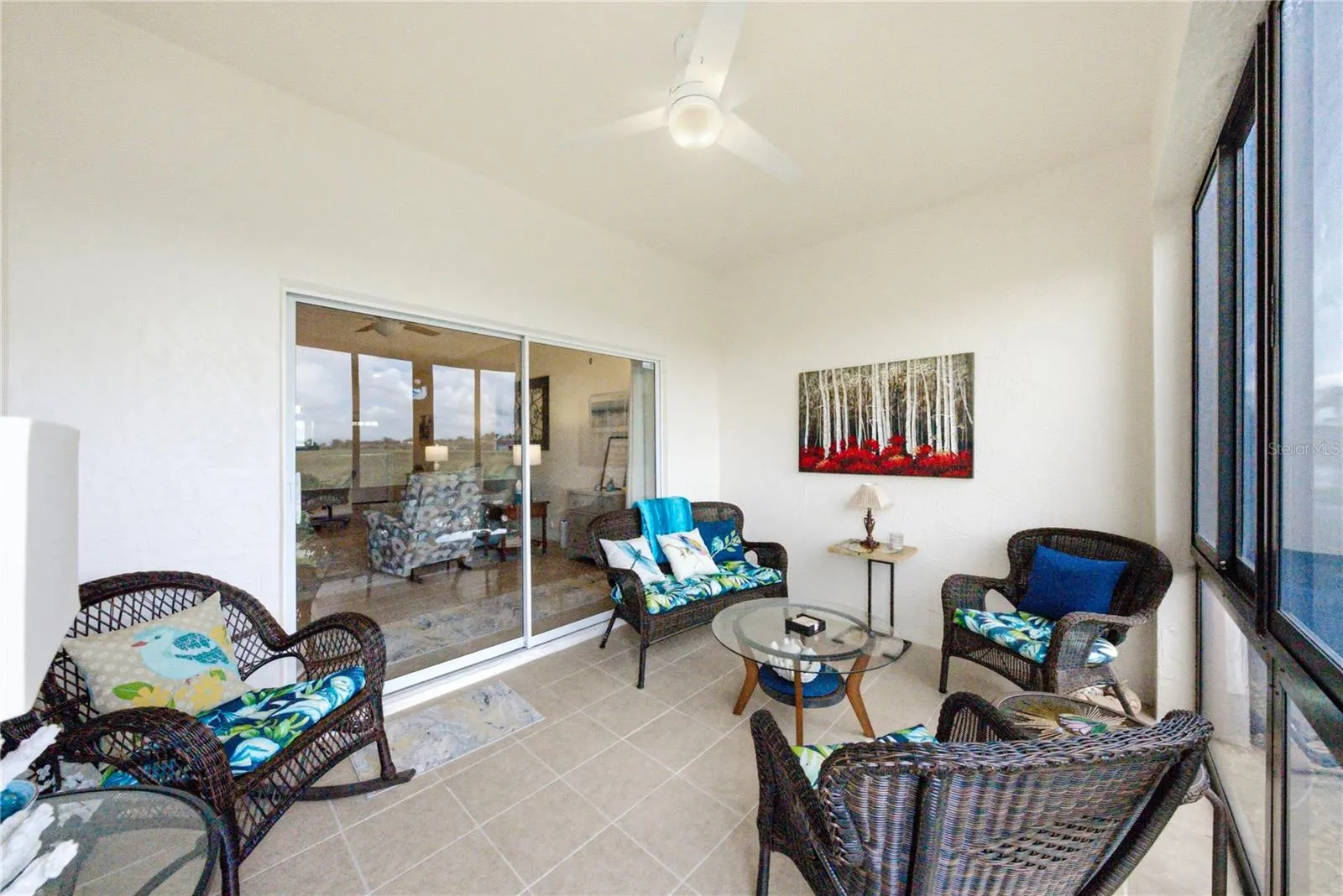 The enclosed lanai has ceramic tile flooring and a ceiling fan with light.