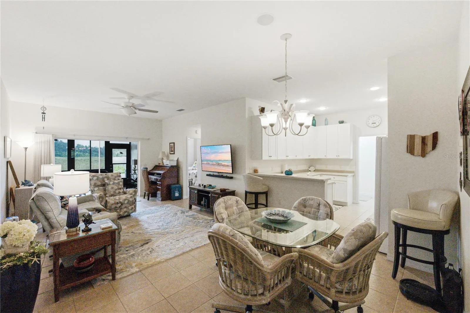 The central core includes the kitchen, dining, and living room. The double slider opens to the enclosed lanai.