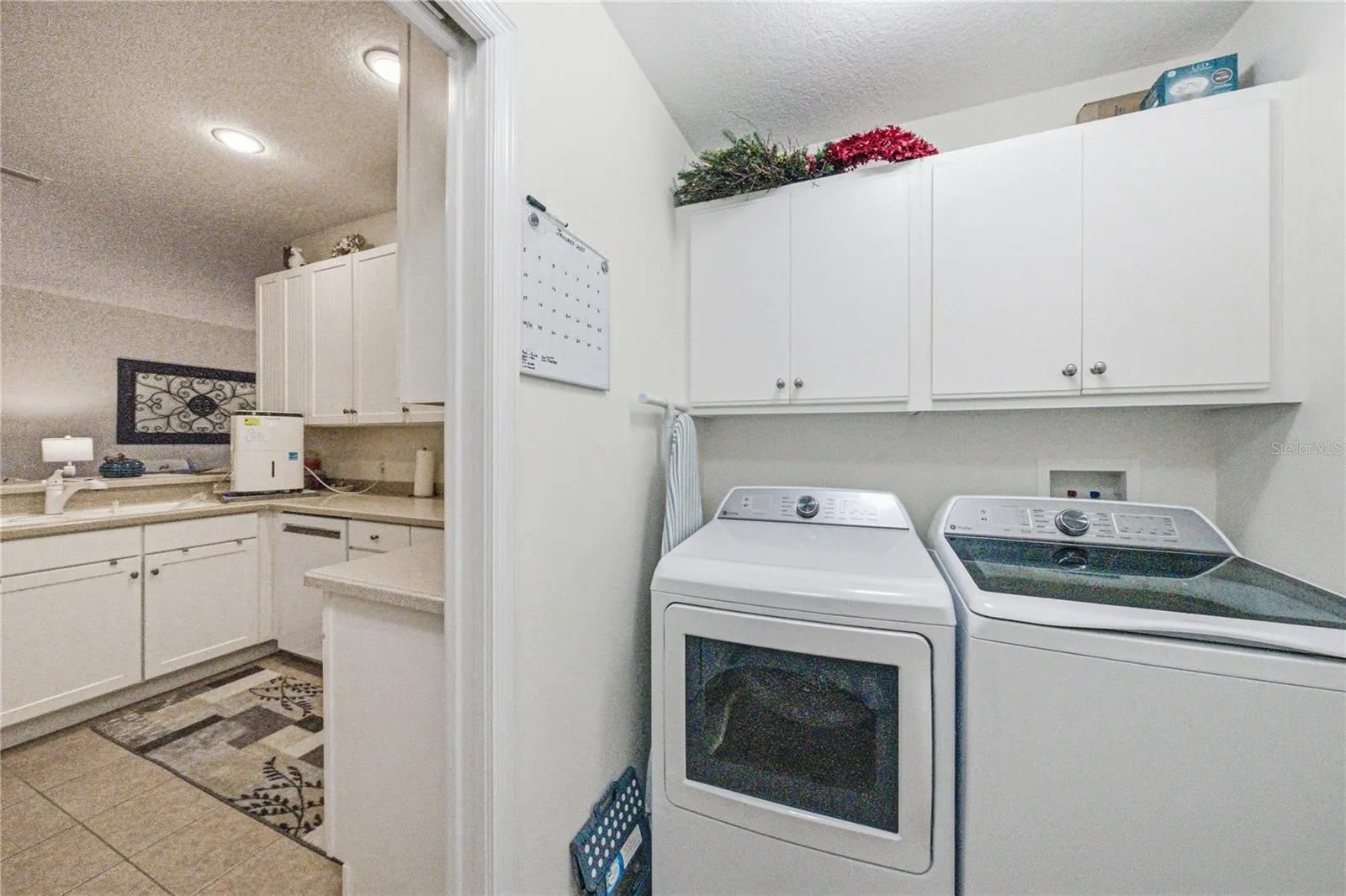 The laundry room has extra cabinets. The washer and dryer stay.