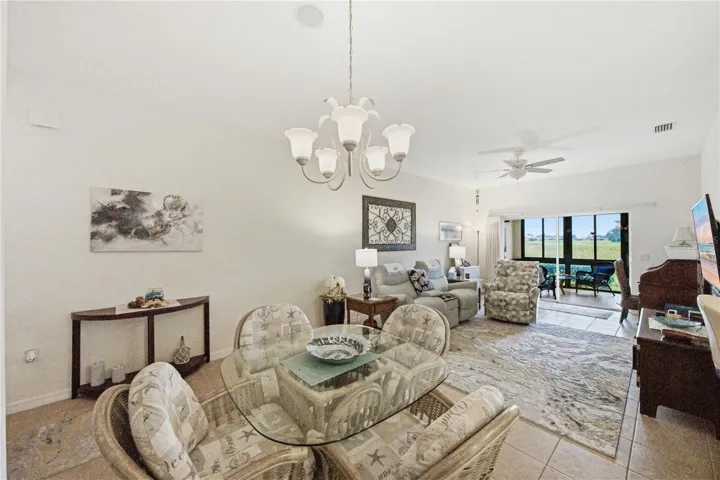 The living room has a custom ceiling fan with light, ceramic tile flooring, and window treatments.
