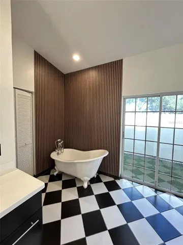 Rich wood paneling with a danity claw foot tub.